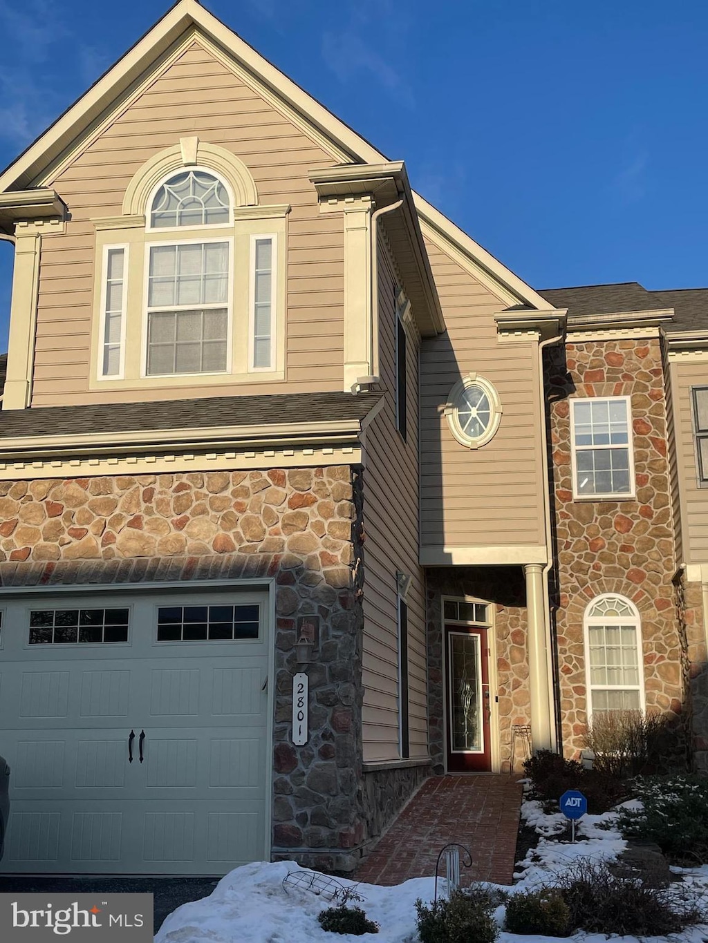 view of front of property with a garage and stone siding