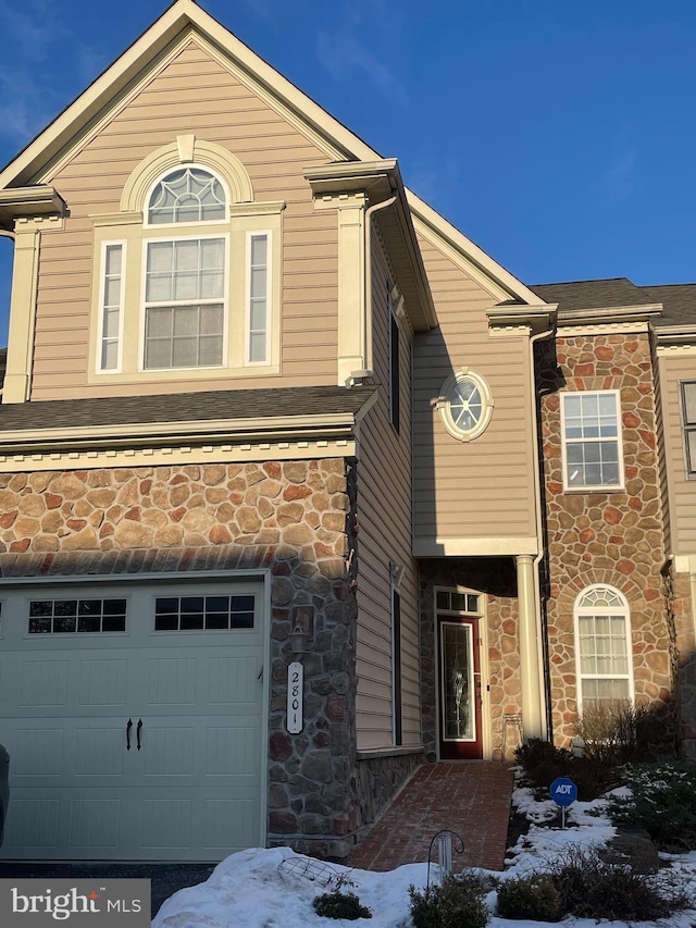 view of front of house with a garage and stone siding