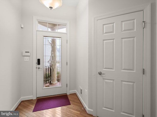 entryway with wood-type flooring and baseboards