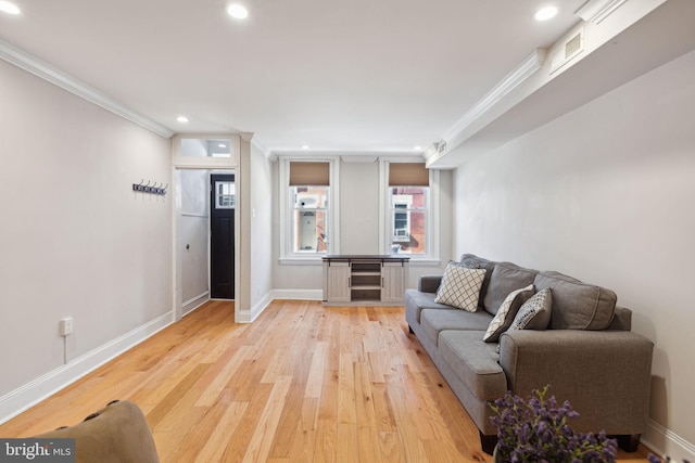 living room with light wood-type flooring and ornamental molding