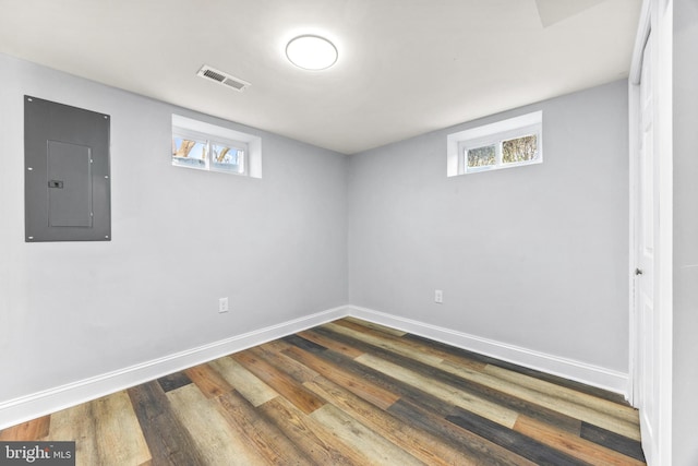 basement featuring dark wood-type flooring and electric panel