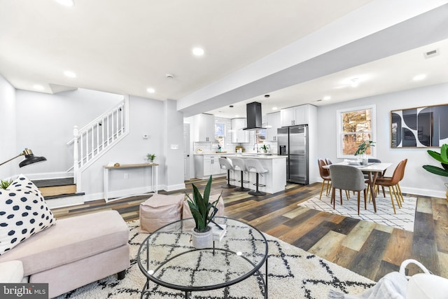 living room with a healthy amount of sunlight, dark hardwood / wood-style flooring, and sink