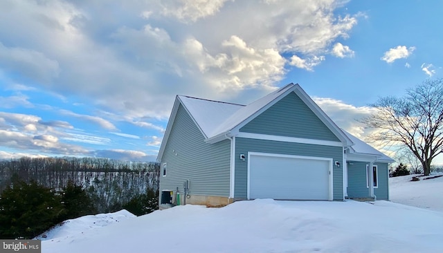 view of snowy exterior with a garage and central AC