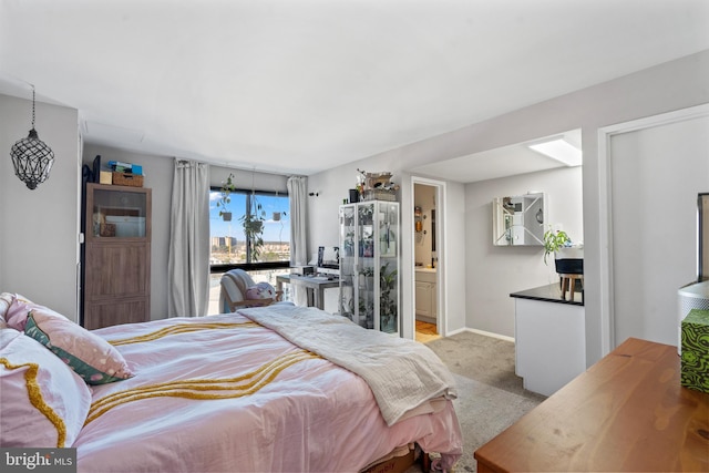 bedroom featuring connected bathroom and light carpet