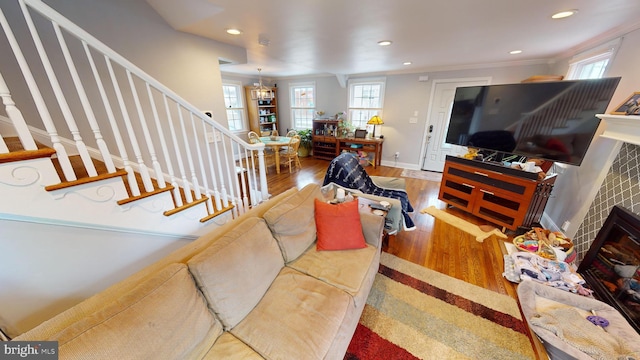 living room featuring a tiled fireplace, hardwood / wood-style flooring, and ornamental molding