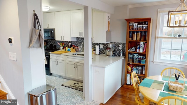 kitchen featuring white cabinetry, gas stove, and pendant lighting