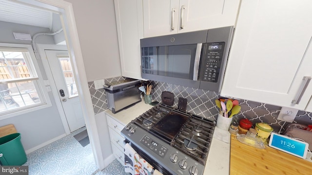 kitchen with white cabinetry, appliances with stainless steel finishes, and backsplash