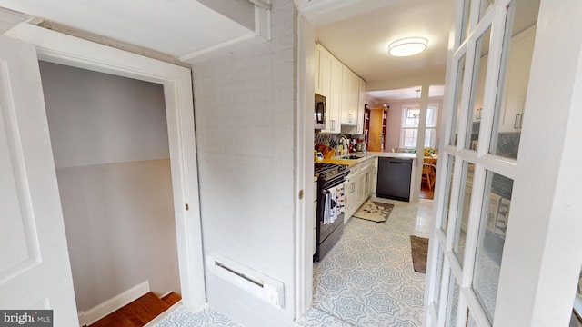 kitchen featuring white cabinets, sink, and black appliances