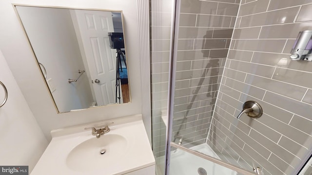 bathroom with a tile shower and sink