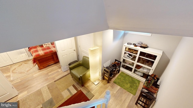 sitting room with hardwood / wood-style flooring and vaulted ceiling