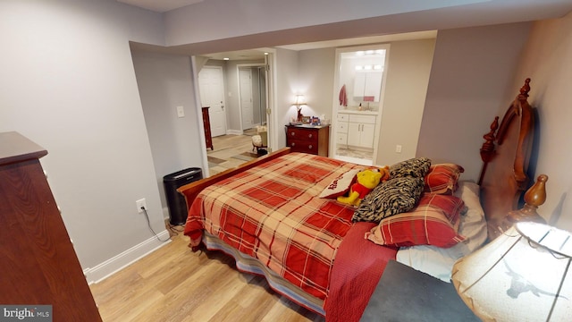 bedroom featuring ensuite bathroom and light wood-type flooring