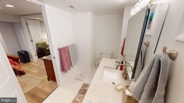 bathroom featuring vanity, toilet, and hardwood / wood-style floors