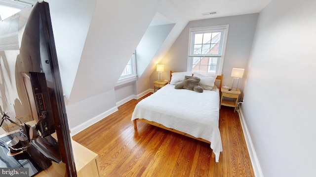 bedroom featuring wood-type flooring and lofted ceiling