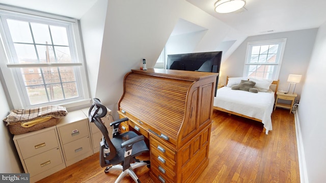 bedroom featuring lofted ceiling and light hardwood / wood-style flooring