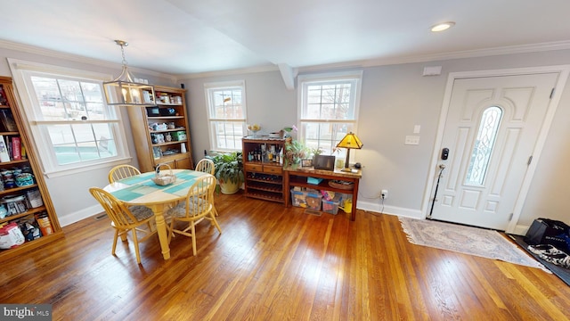 dining area with ornamental molding and hardwood / wood-style floors