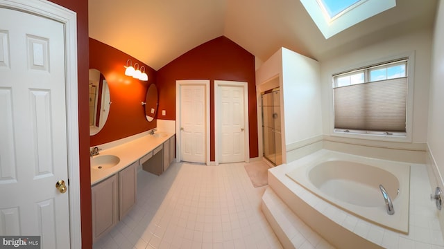 bathroom featuring vanity, tile patterned flooring, vaulted ceiling with skylight, and separate shower and tub