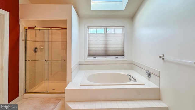 bathroom featuring a skylight and separate shower and tub