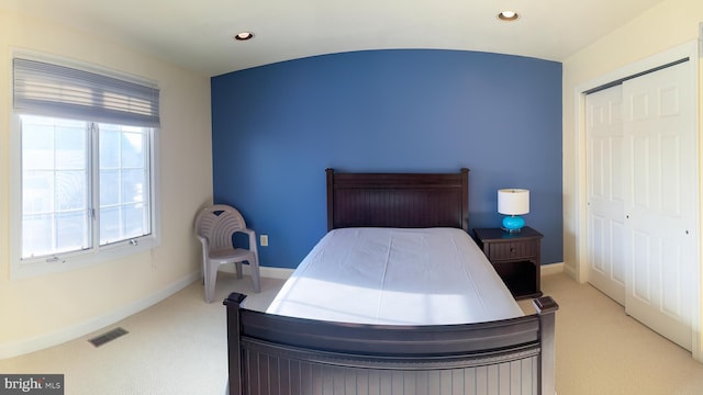 bedroom featuring light carpet and a closet