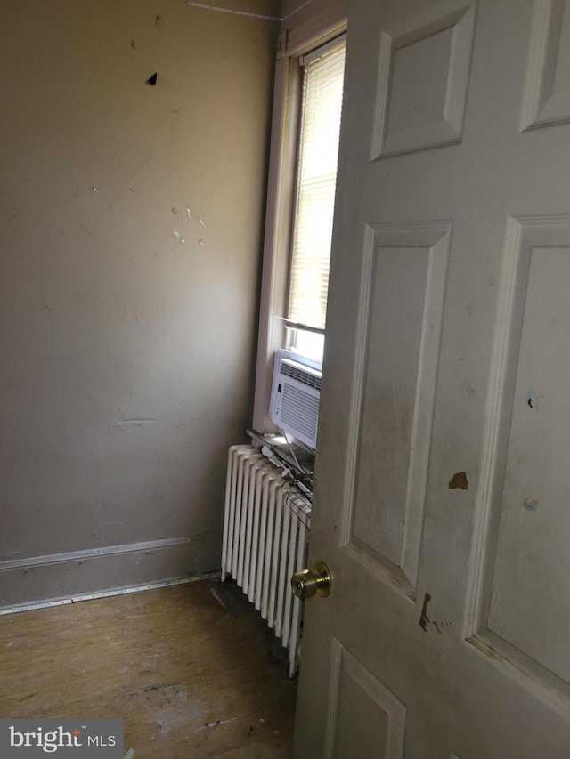 interior space featuring plenty of natural light, radiator heating unit, and cooling unit