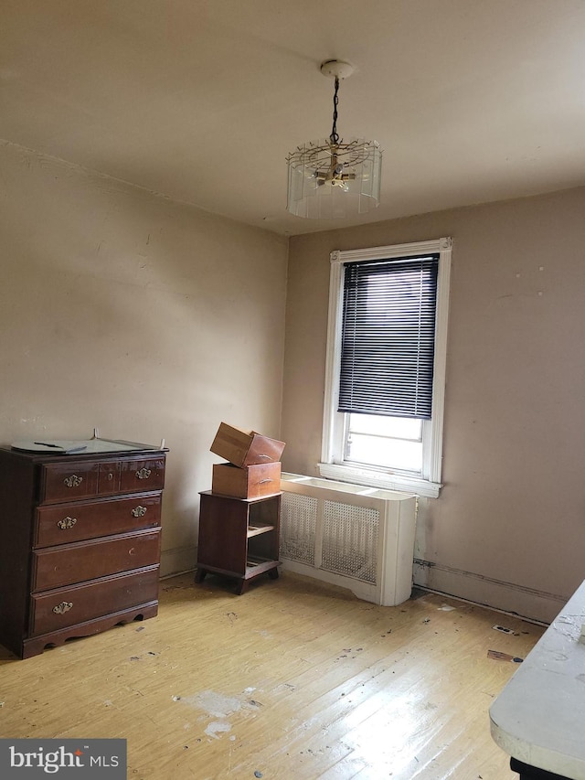 bedroom featuring a notable chandelier and light wood-type flooring