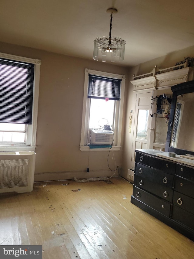 unfurnished bedroom featuring cooling unit and light hardwood / wood-style floors