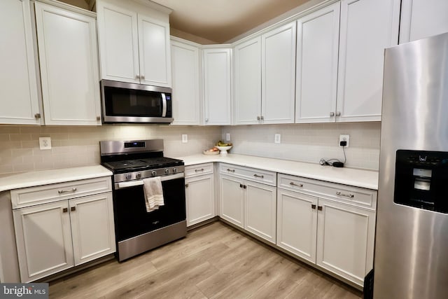 kitchen with stainless steel appliances, light countertops, and white cabinetry