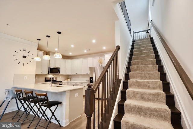 staircase featuring baseboards, wood finished floors, and recessed lighting