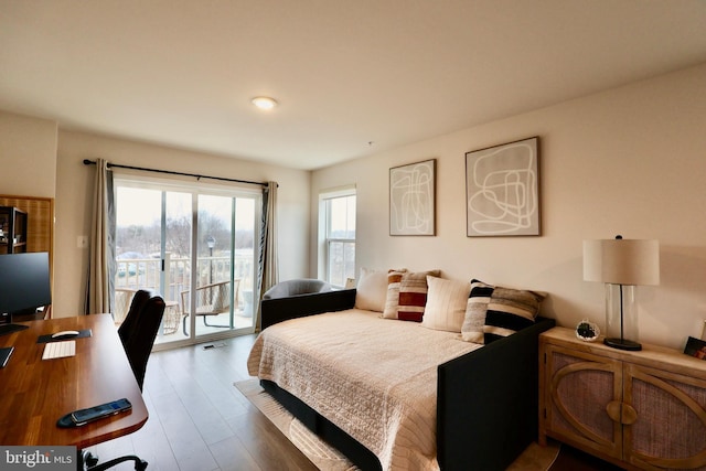 bedroom featuring access to outside and wood finished floors