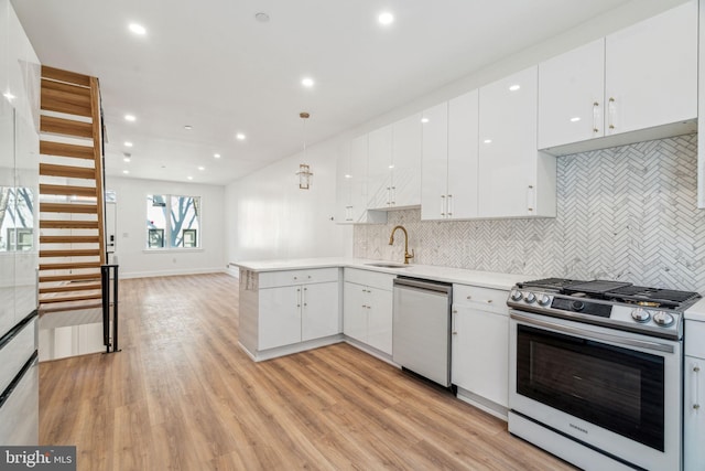 kitchen with white cabinetry, kitchen peninsula, hanging light fixtures, and stainless steel appliances