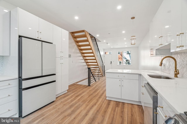 kitchen with dishwasher, white cabinetry, white refrigerator, light hardwood / wood-style floors, and sink