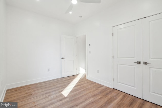 unfurnished bedroom with ceiling fan, a closet, and light hardwood / wood-style flooring