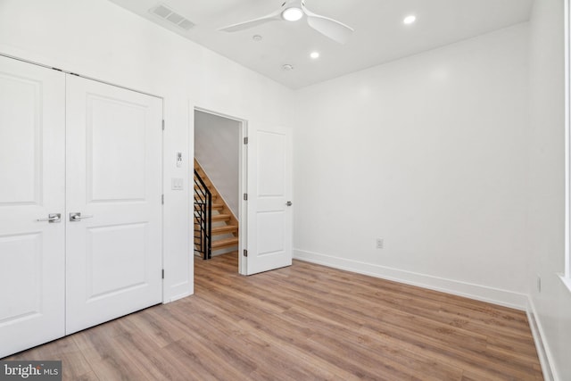 unfurnished bedroom with light hardwood / wood-style flooring, a closet, and ceiling fan