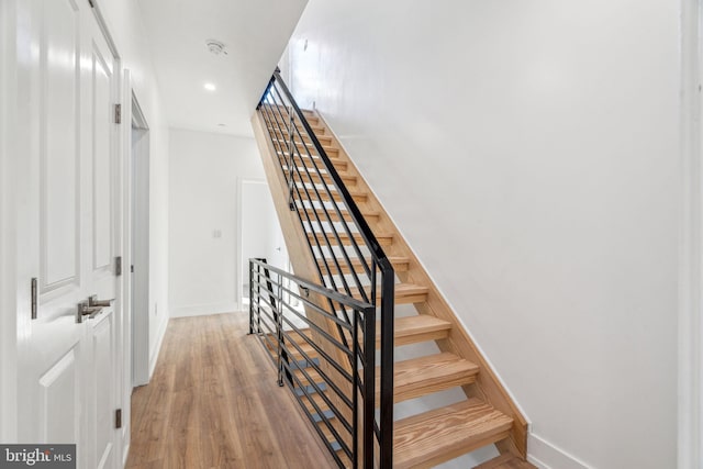 staircase with hardwood / wood-style flooring