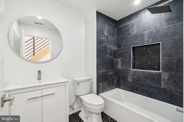 full bathroom featuring tiled shower / bath combo, toilet, and vanity