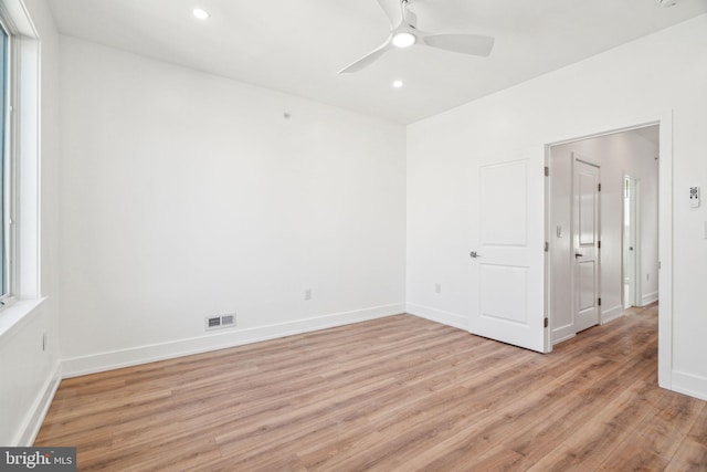 empty room featuring light wood-type flooring, a wealth of natural light, and ceiling fan