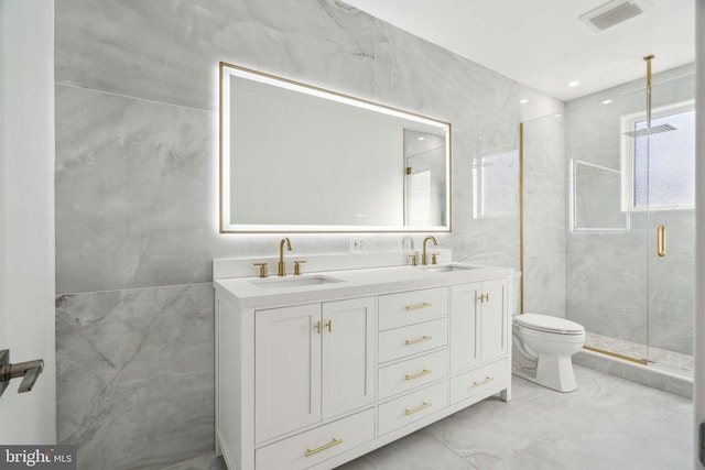 bathroom with a shower with shower door, tile walls, and vanity