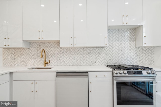 kitchen with stainless steel gas stove, dishwasher, sink, white cabinetry, and tasteful backsplash