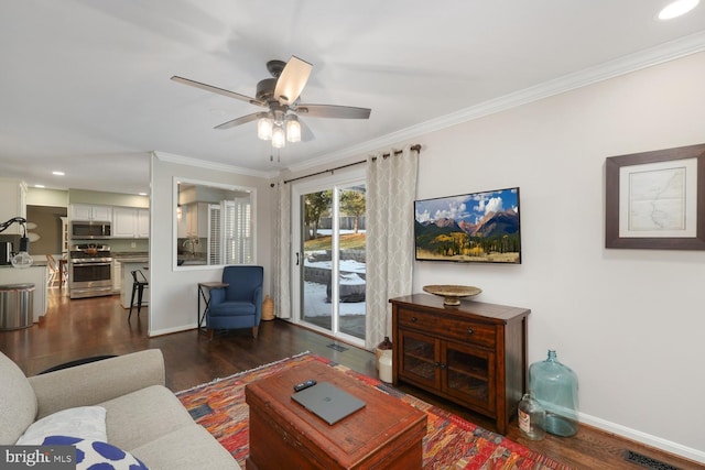 living room with ornamental molding, dark hardwood / wood-style floors, and ceiling fan