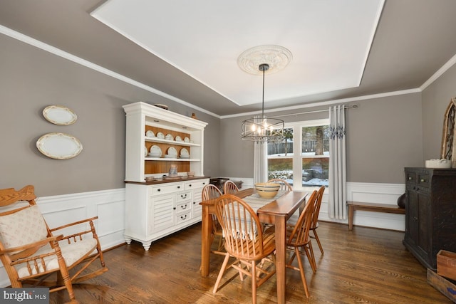 dining area with an inviting chandelier, crown molding, and dark wood-type flooring