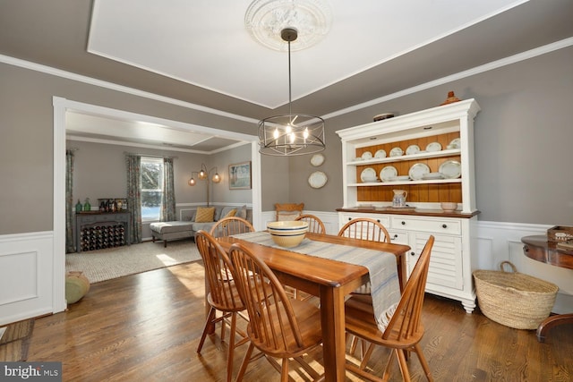 dining space featuring ornamental molding, dark hardwood / wood-style flooring, and a chandelier