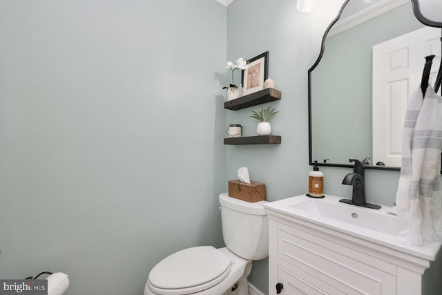 bathroom with crown molding, vanity, and toilet