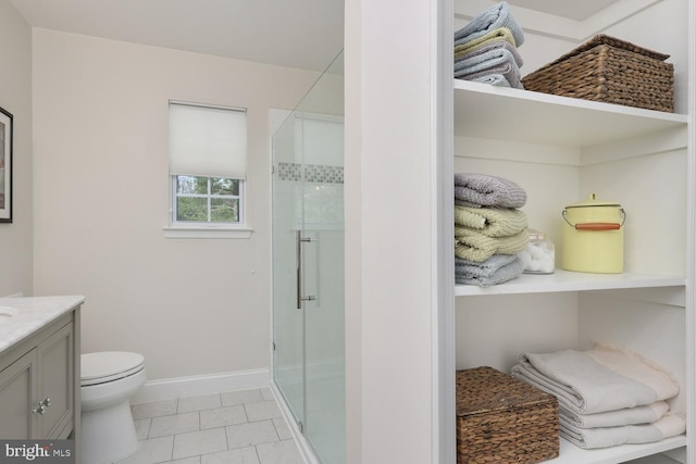 bathroom featuring vanity, toilet, and a shower with shower door