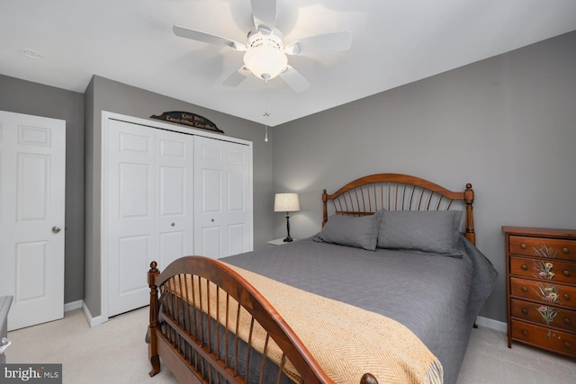 bedroom featuring ceiling fan, light carpet, and a closet