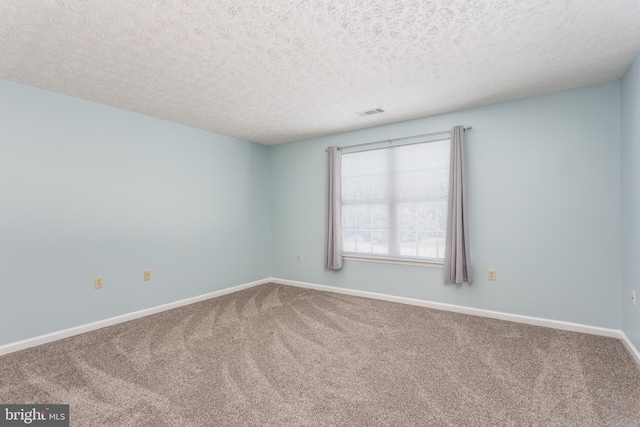 unfurnished room featuring carpet flooring and a textured ceiling