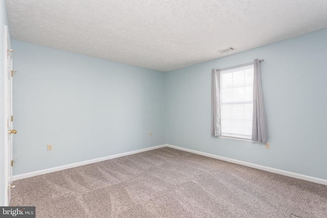 carpeted spare room with a textured ceiling