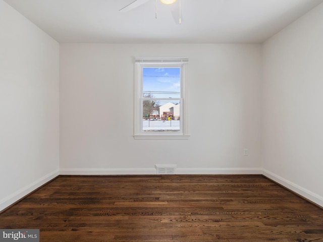 empty room with ceiling fan and dark wood-type flooring