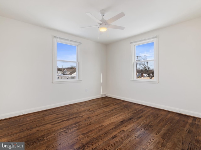 unfurnished room featuring ceiling fan, dark wood-type flooring, and plenty of natural light