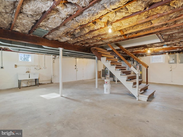 basement featuring sink, electric panel, and water heater