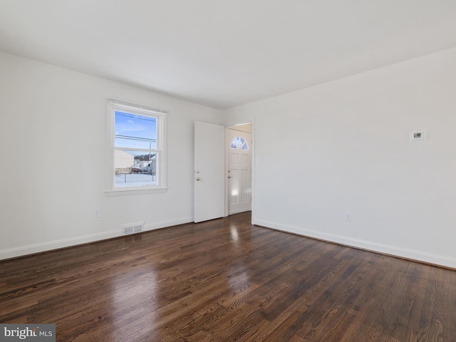 spare room with dark hardwood / wood-style floors