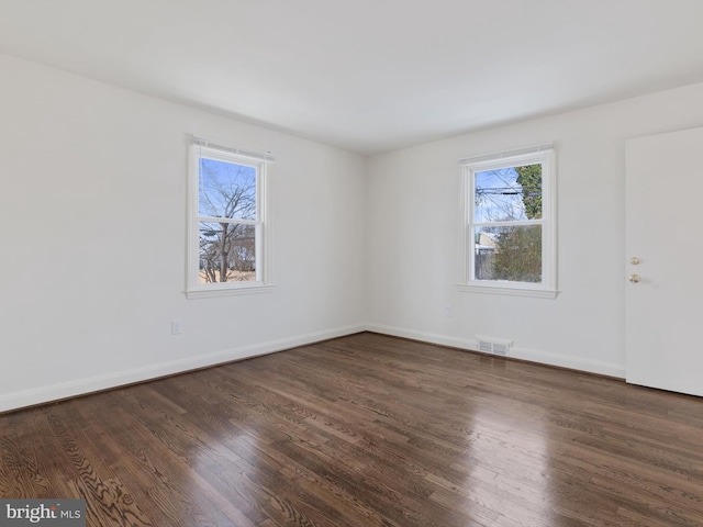 spare room with dark wood-type flooring